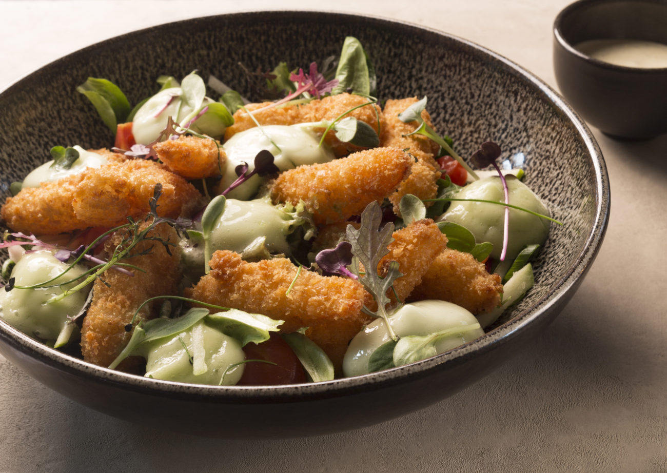 Een gerecht uit de keuken van HautRu met krokante hapjes, crème en verse kruiden.